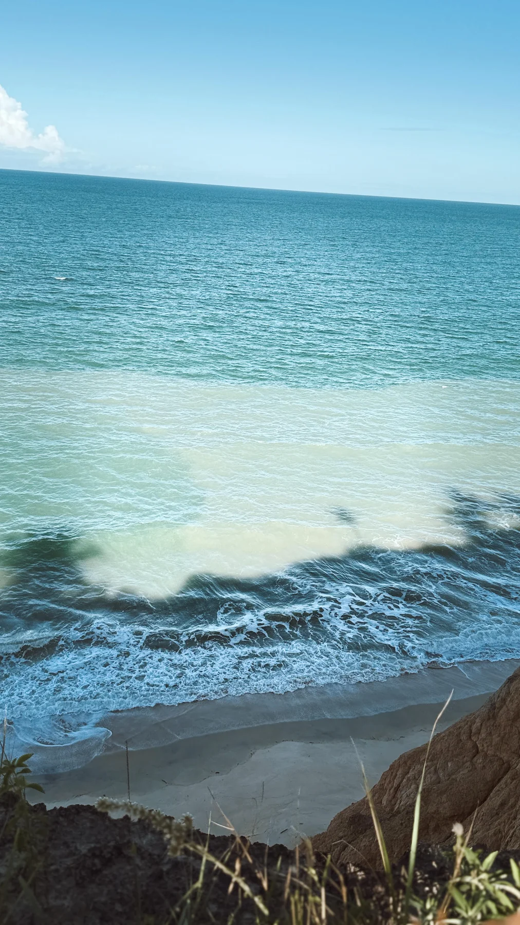 Mar e ondas quebrando na praia vistos do alto