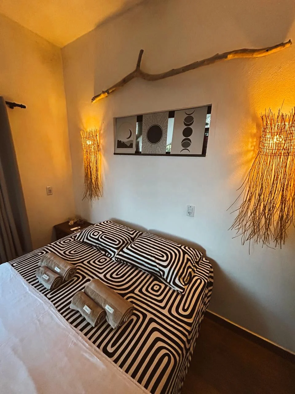 Suíte com luminárias de fibra e quadro das fases da lua